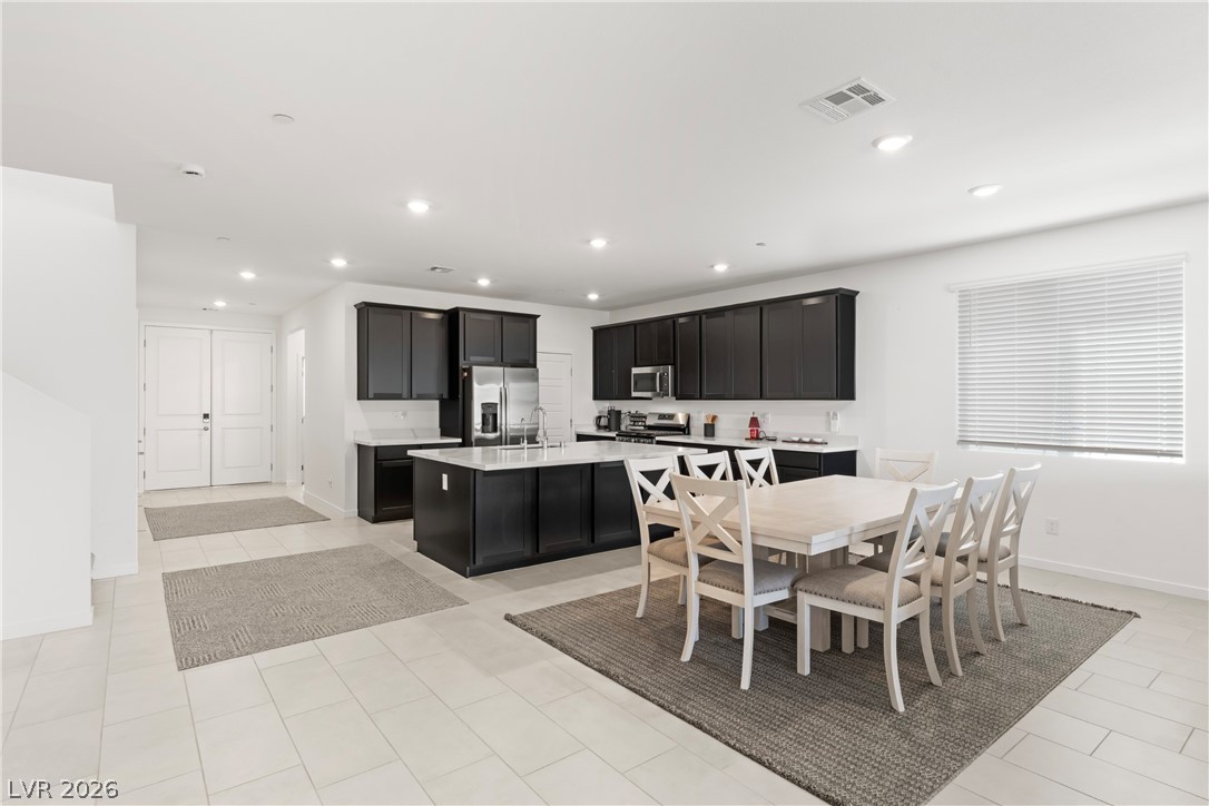 320 Isla Enclave Way Henderson, NV 89011 - Photo 6 of 49 This spacious kitchen and dining area features abundant cabinetry, modern appliances, and seamless access to the home's entry.