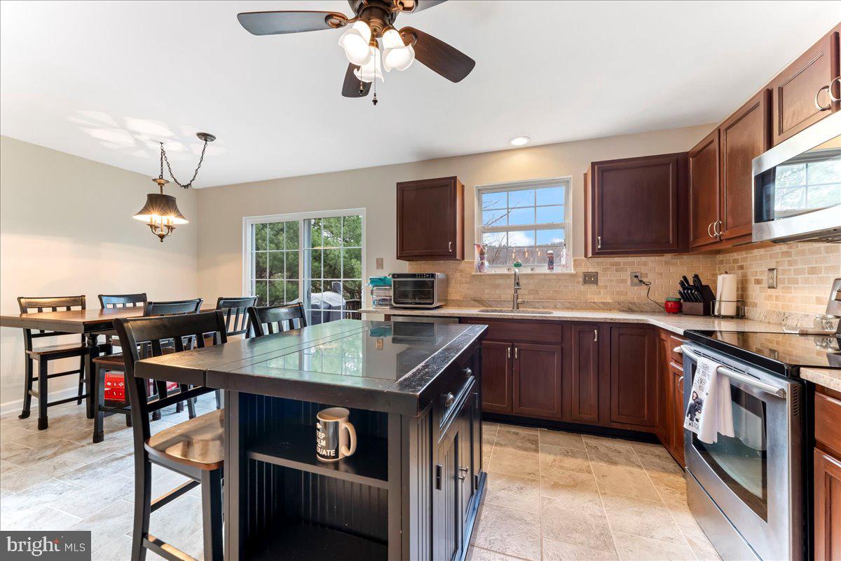 6 Marc Drive Coatesville, PA 19320 - Photo 9 of 25 a kitchen with a stove a sink a dining table and chairs