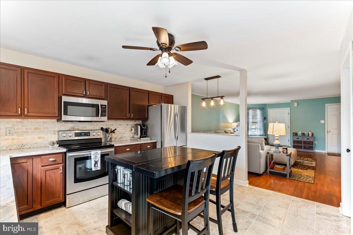 6 Marc Drive Coatesville, PA 19320 - Photo 10 of 25 a dining room with stainless steel appliances kitchen island granite countertop a dining table and chairs
