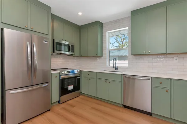 a kitchen with stainless steel appliances granite countertop a refrigerator sink and microwave