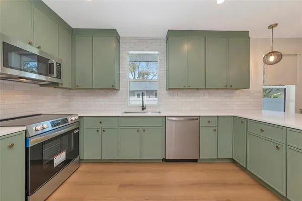 a kitchen with cabinets a sink and stainless steel appliances