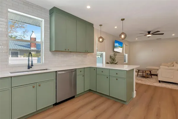 a kitchen with a sink cabinets and wooden floor