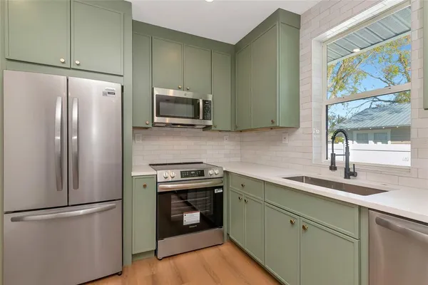 a kitchen with stainless steel appliances a refrigerator sink and microwave