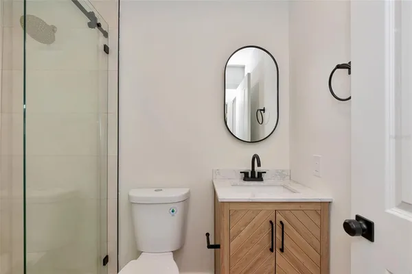 a bathroom with a toilet a sink and mirror