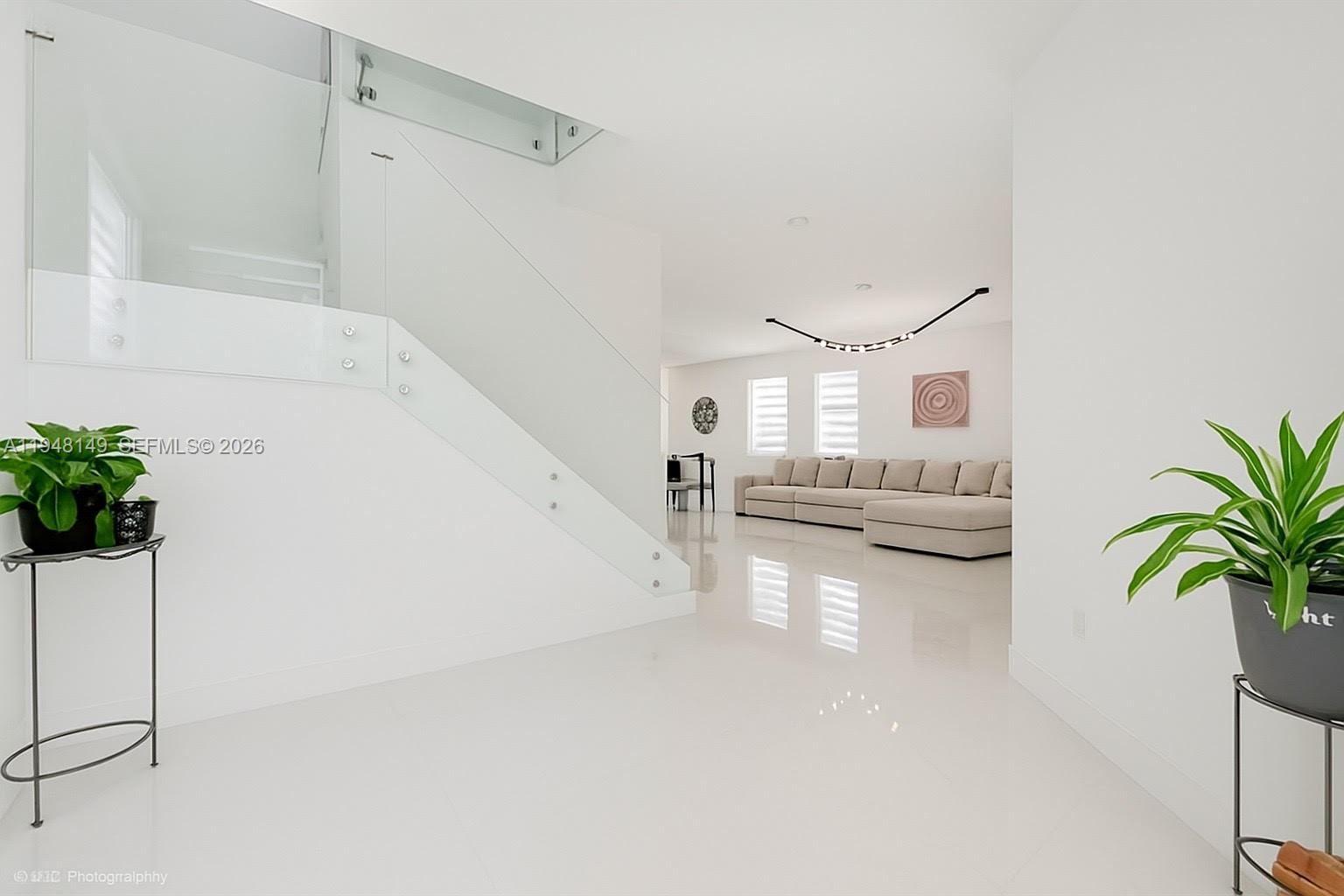 11711 Southwest 254th Street Homestead, FL 33032 - Photo 2 of 17 a view of a hallway with a dining table and chairs
