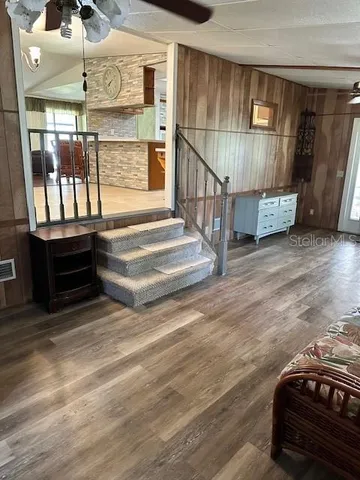 a view of a hallway with wooden floor and staircase