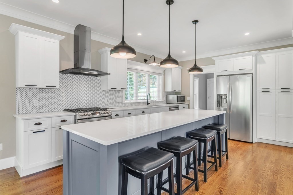 273 Scantic Road Hampden, MA 01036 - Photo 11 of 40 a kitchen with stainless steel appliances granite countertop a stove a sink a oven a kitchen island with wooden cabinets and wooden floor