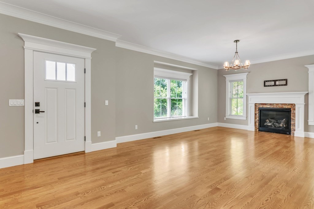 273 Scantic Road Hampden, MA 01036 - Photo 4 of 40 an empty room with wooden floor fireplace and windows