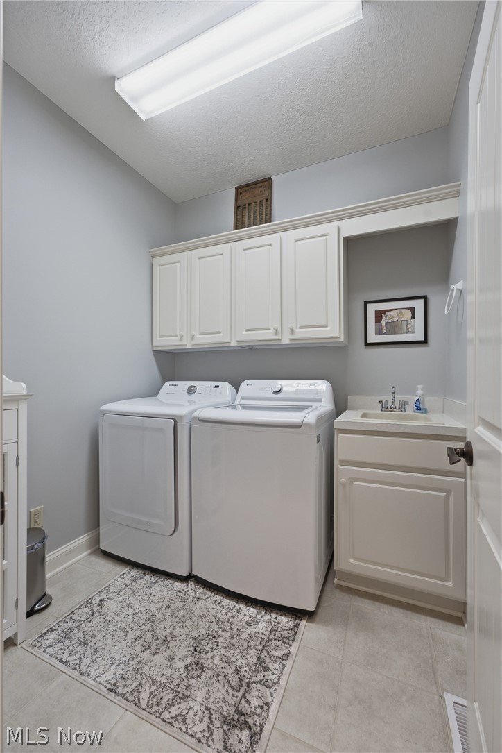 3955 Spring Brook Way Wooster, OH 44691 - Photo 21 of 50 Laundry area featuring overhead cabinetry, a built-in sink with countertop, and tile flooring