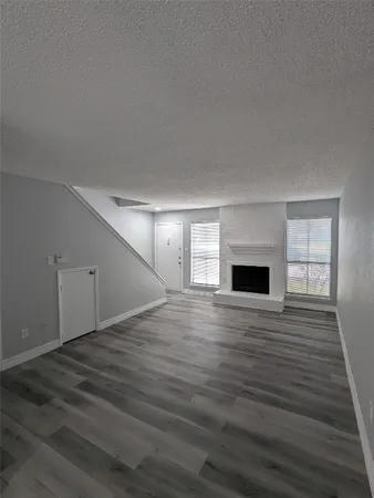a view of empty room with wooden floor and fireplace