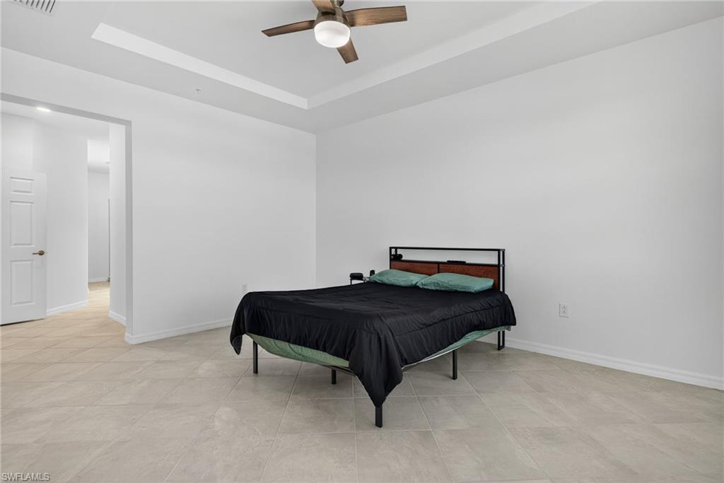 12041 Santaluz Drive, Unit 202 Fort Myers, FL 33913 - Photo 14 of 42 Primary Bedroom with a ceiling fan and a tray ceiling
