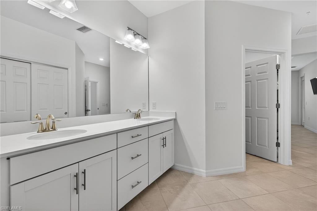 12041 Santaluz Drive, Unit 202 Fort Myers, FL 33913 - Photo 16 of 42 En Suite Bathroom featuring double vanity and light tile patterned flooring