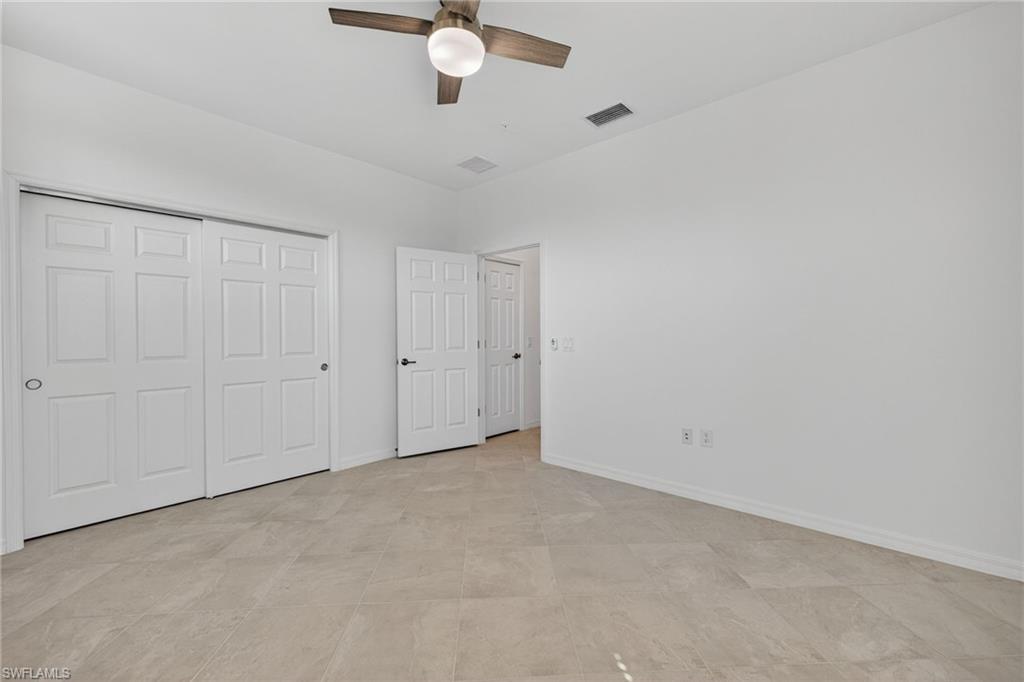 12041 Santaluz Drive, Unit 202 Fort Myers, FL 33913 - Photo 19 of 42 Unfurnished bedroom with a ceiling fan and a closet