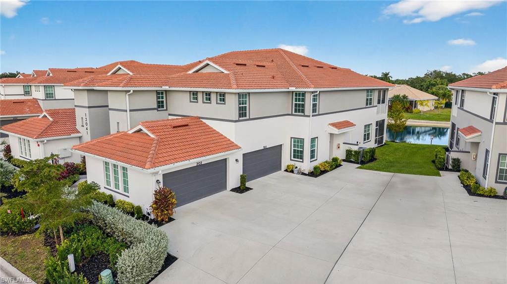 12041 Santaluz Drive, Unit 202 Fort Myers, FL 33913 - Photo 26 of 42 View of front of home featuring stucco siding, a garage, concrete driveway, and a tiled roof