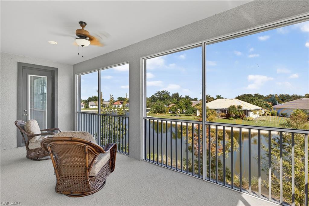 12041 Santaluz Drive, Unit 202 Fort Myers, FL 33913 - Photo 4 of 42 Sunroom featuring a water view, a textured wall, and carpet floors
