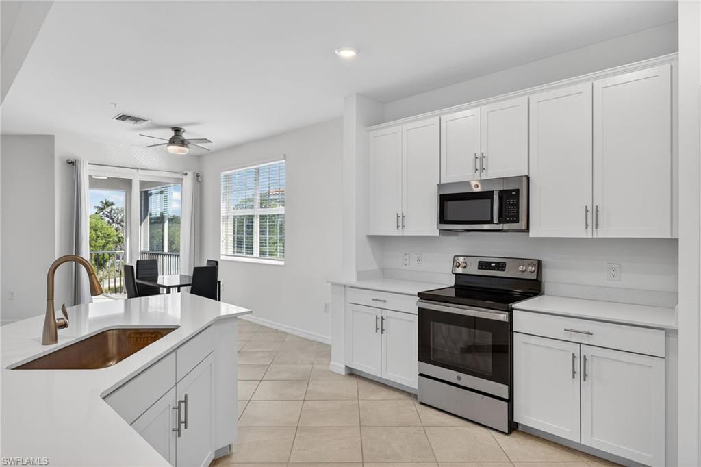 12041 Santaluz Drive, Unit 202 Fort Myers, FL 33913 - Photo 6 of 42 Kitchen featuring stainless steel appliances, white cabinets, light tile patterned flooring, recessed lighting, and ceiling fan