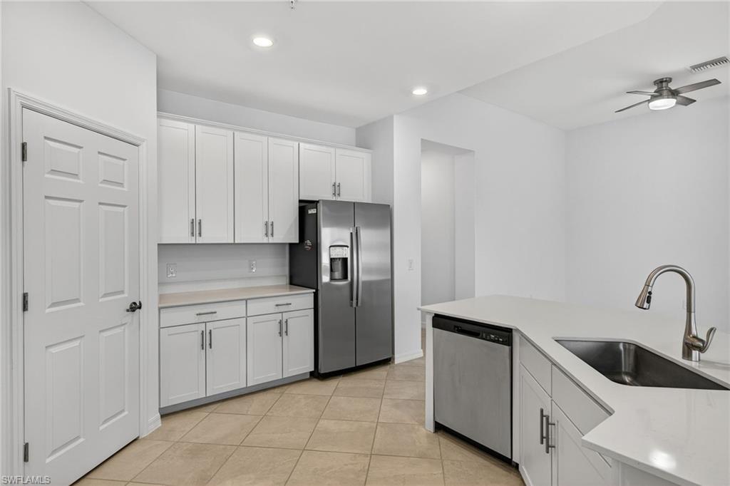 12041 Santaluz Drive, Unit 202 Fort Myers, FL 33913 - Photo 7 of 42 Kitchen featuring stainless steel appliances, white cabinetry, ceiling fan, light tile patterned floors, and recessed lighting