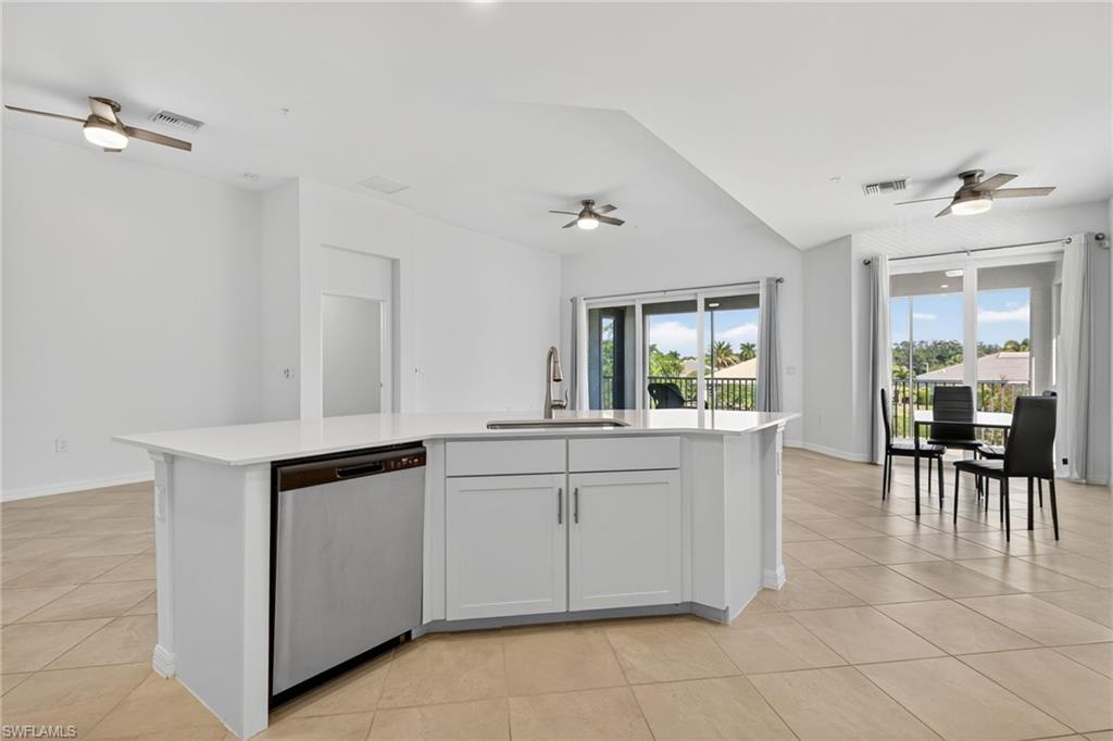 12041 Santaluz Drive, Unit 202 Fort Myers, FL 33913 - Photo 9 of 42 Kitchen with a ceiling fan, a center island with sink, dishwasher, and light tile patterned flooring