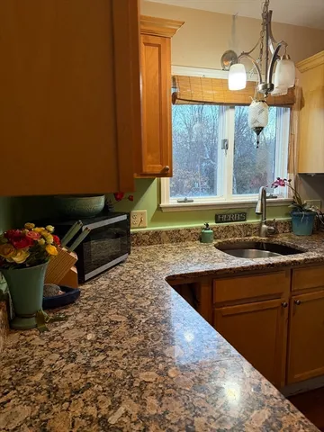 a kitchen with stainless steel appliances granite countertop a sink dishwasher and a black countertop with white cabinets