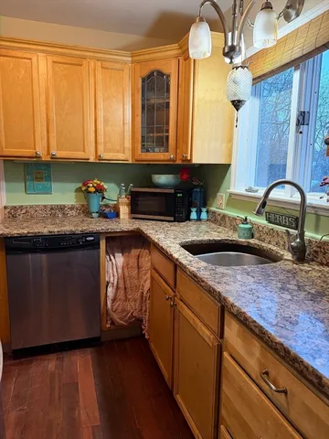 a kitchen with granite countertop a sink a stove and cabinets