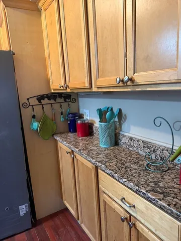 a kitchen with a granite countertop sink and cabinets