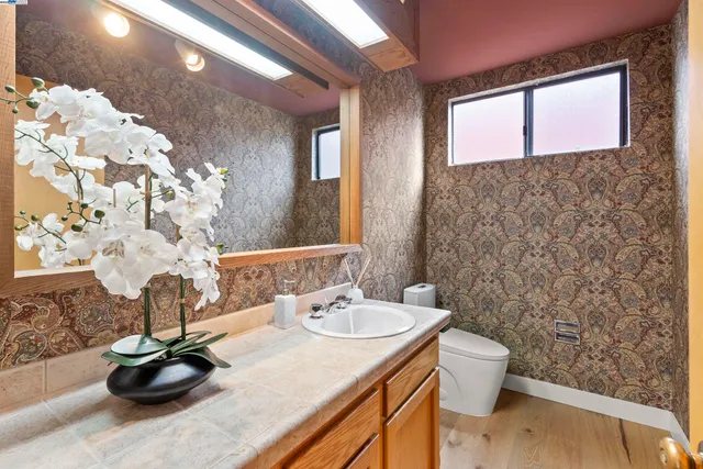a bathroom with a sink a toilet and mirror