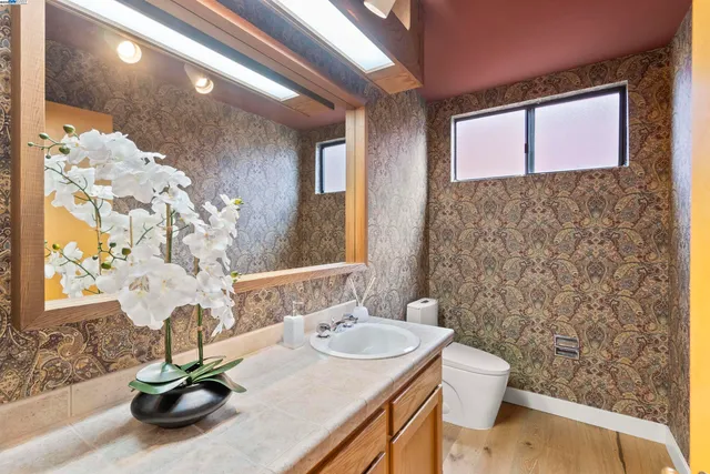 a bathroom with a sink a toilet and a mirror