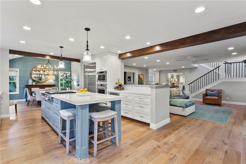 a kitchen with kitchen island a large counter top space a sink appliances and living room view