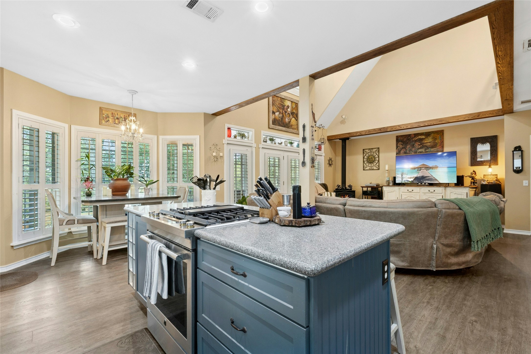 412 Woody Hollow Road Luling, TX 78648 - Photo 11 of 33 Kitchen featuring stainless steel gas range oven, blue cabinets, a center island, hanging light fixtures, and dark wood-style floors
