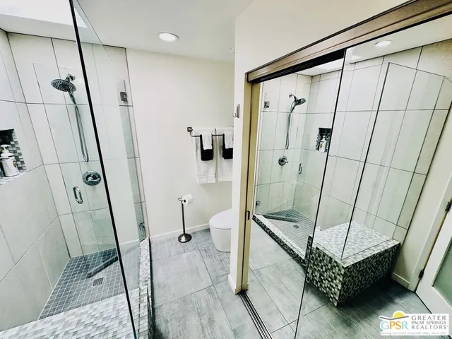 a view of a swimming pool with potted plants and a bench in front of it