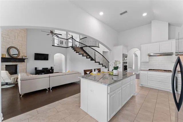 a kitchen with granite countertop a sink and white cabinets