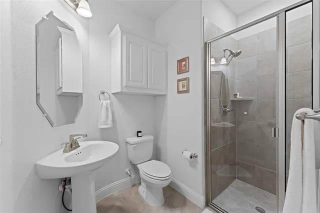 a bathroom with a sink toilet a mirror and shower