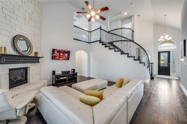 a living room with furniture a fireplace and wooden floor