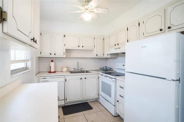a kitchen with white cabinets and white appliances