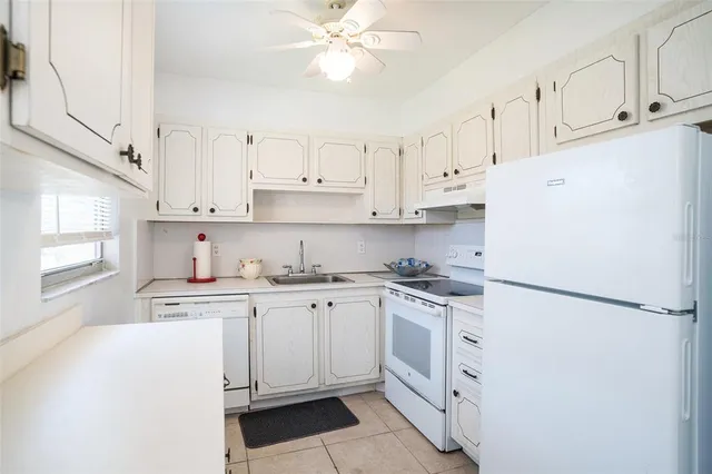 a kitchen with white cabinets and white appliances