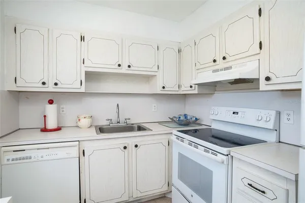 a kitchen with white cabinets and white appliances