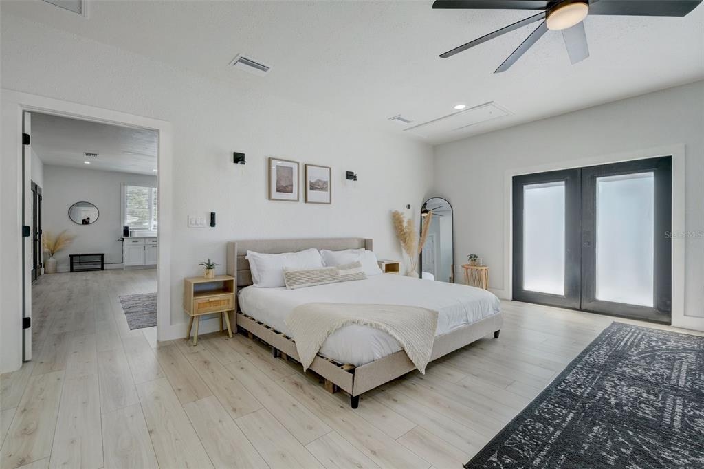 3030 Ashton Road Sarasota, FL 34231 - Photo 22 of 41 a bedroom with a large bed and a chandelier