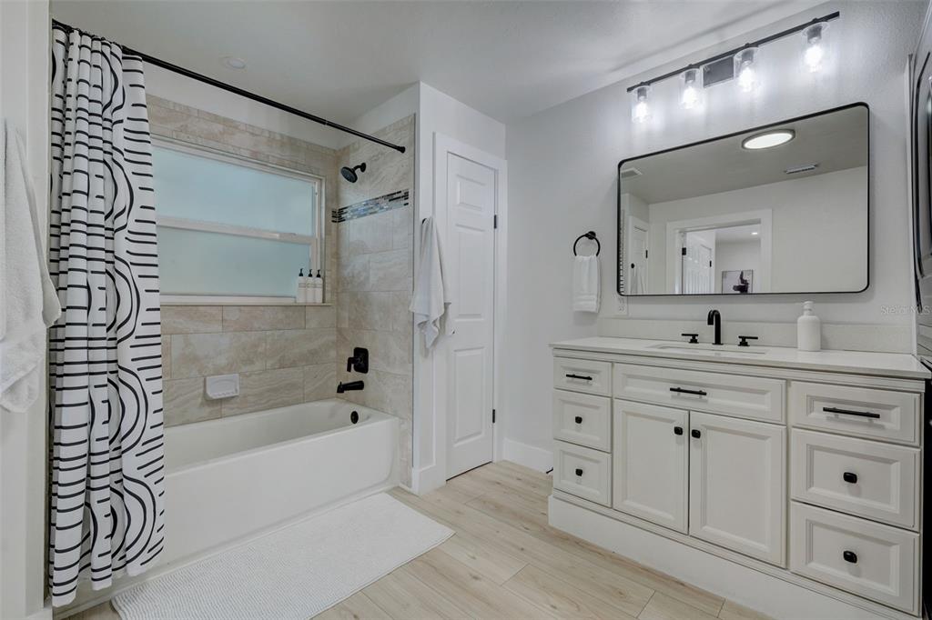 3030 Ashton Road Sarasota, FL 34231 - Photo 26 of 41 a spacious bathroom with a granite countertop sink a mirror a shower and a bathtub