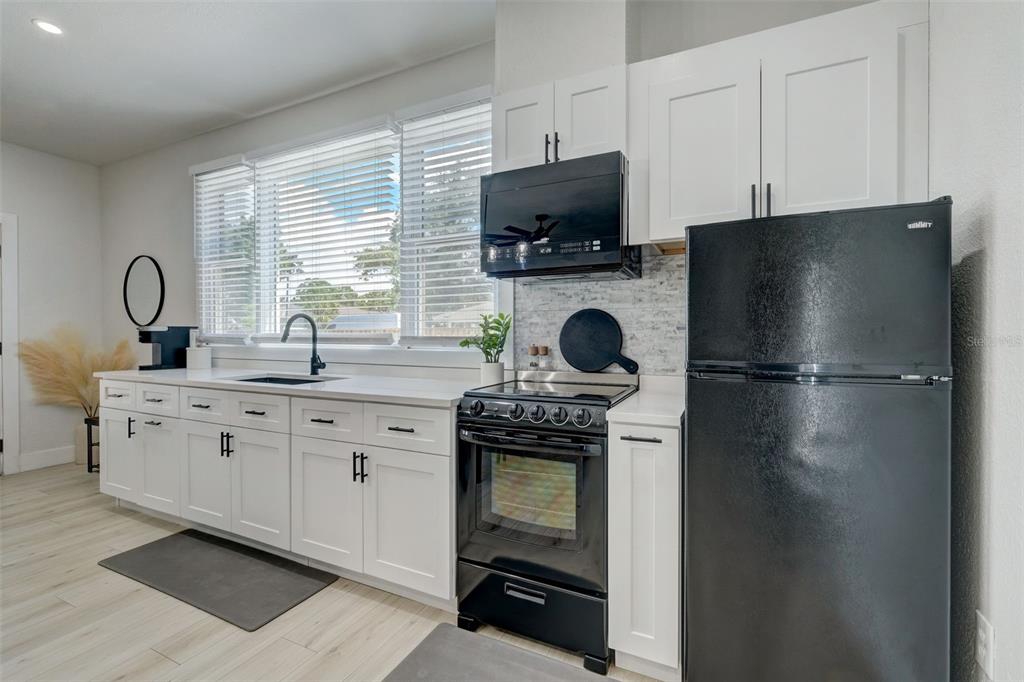 3030 Ashton Road Sarasota, FL 34231 - Photo 3 of 41 a kitchen with a stove a sink and a refrigerator