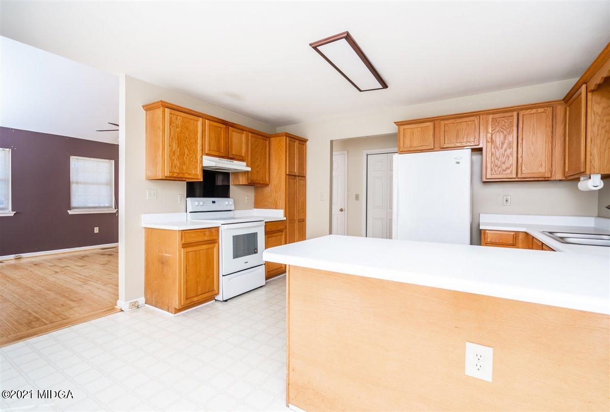 306 Jason Court Macon, GA 31216 - Photo 20 of 22 a kitchen with a refrigerator a stove top oven a sink and dishwasher