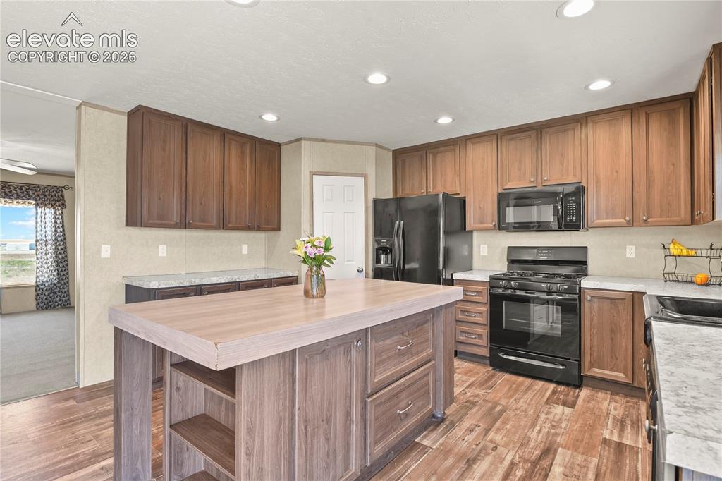 22280 Jones Road Peyton, CO 80831 - Photo 12 of 47 a kitchen with a sink a stove a refrigerator and cabinets