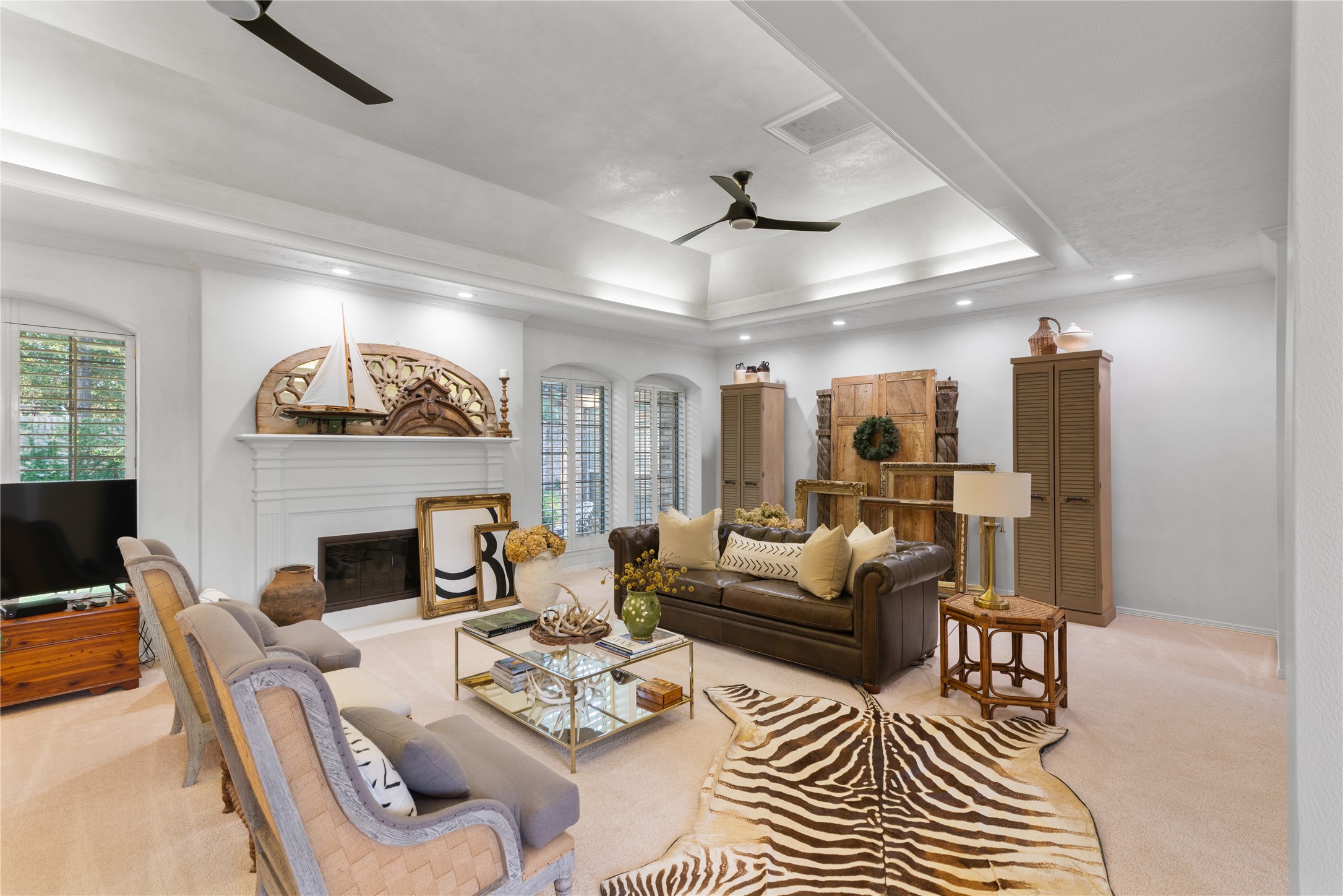 901 Longmire Road, Unit 51 Conroe, TX 77304 - Photo 9 of 48 Spacious living room featuring a cozy fireplace, elegant coffered ceiling, and a blend of traditional and modern decor with ample natural light.