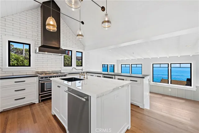 a kitchen with stainless steel appliances granite countertop a stove and a large window