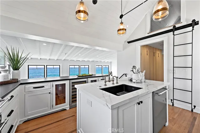 a kitchen that has a lot of cabinets in it and wooden floor
