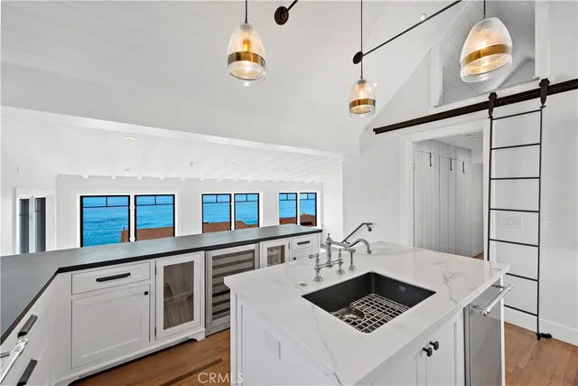 a kitchen with a sink stainless steel appliances furniture and a window