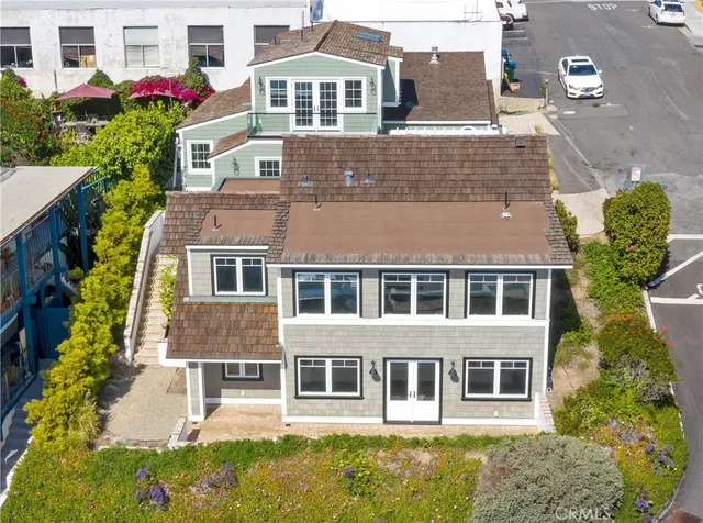 a view of a house with a large window and flower plants