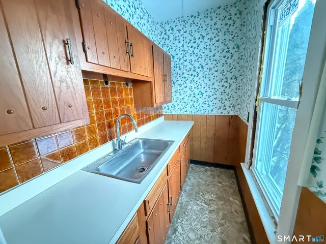 a kitchen with stainless steel appliances granite countertop a refrigerator a stove and a sink with wooden cabinets