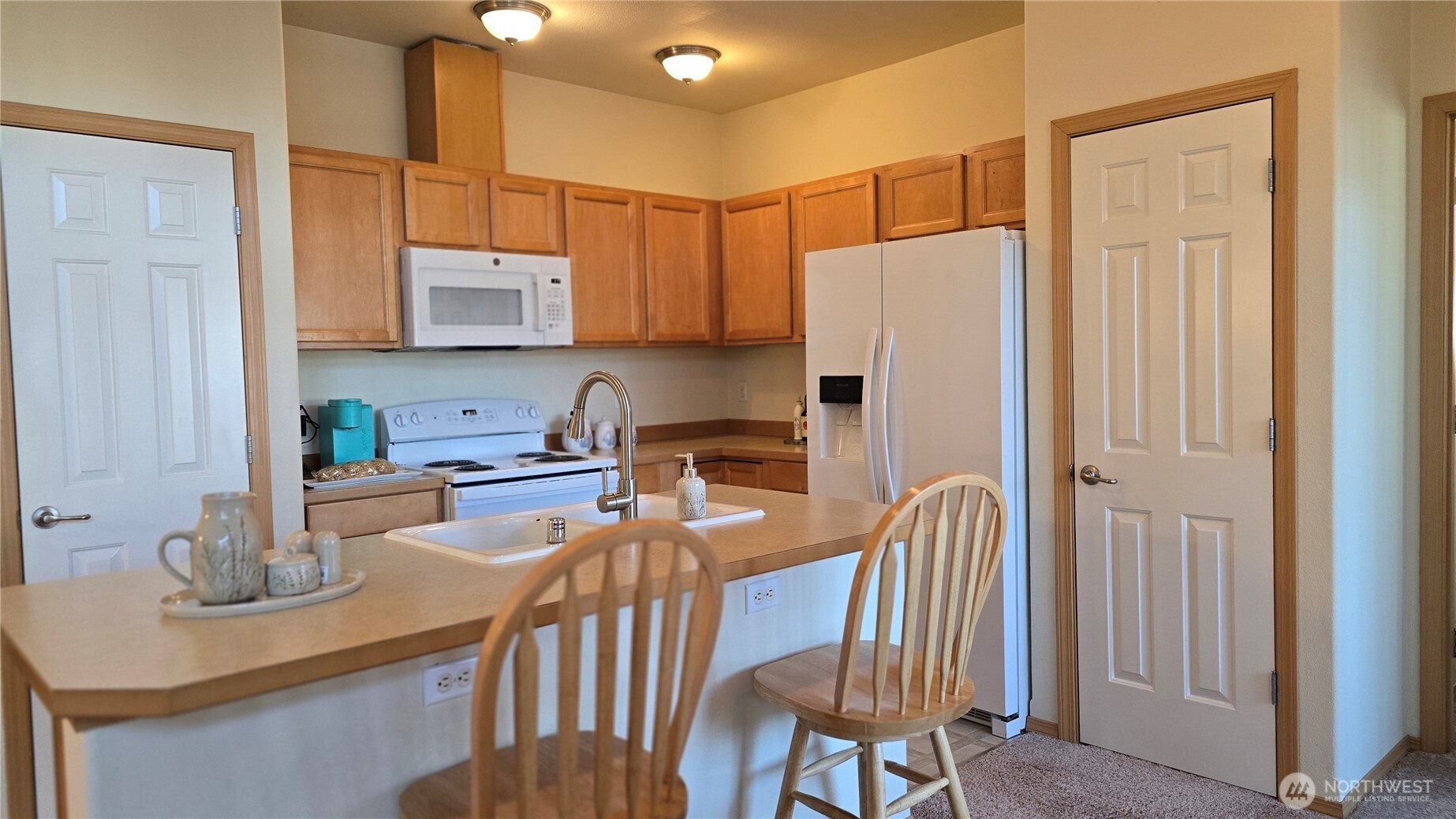 1373 Hudson Street DuPont, WA 98327 - Photo 6 of 12 a kitchen with stainless steel appliances granite countertop a refrigerator a sink a stove a dining table and chairs with wooden floor