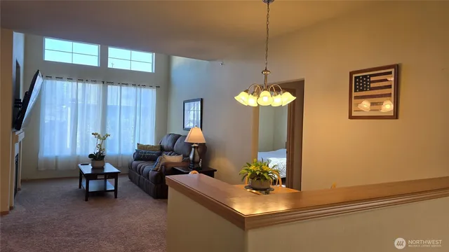 a living room with furniture a chandelier and a window