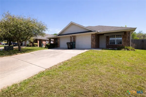 a view of a house with a yard and garage